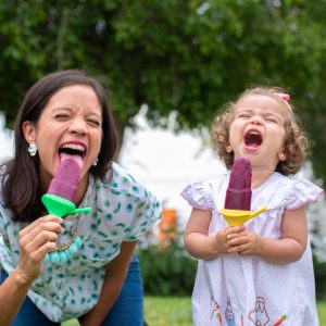Maria Sierra (La Cooquette) and her toddler enjoying a beet banana blueberry popsicle
