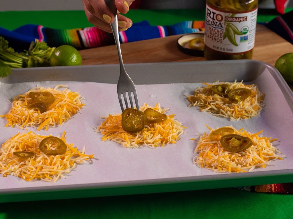 Grated cheddar and sliced jalapeños on a baking tray