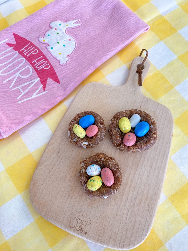 small kids sized cutting board has cute colorful easy bird's nest on top