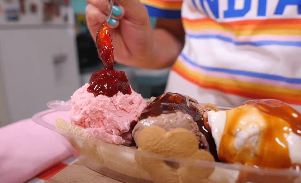 Adding the strawberry jam to the ice cream