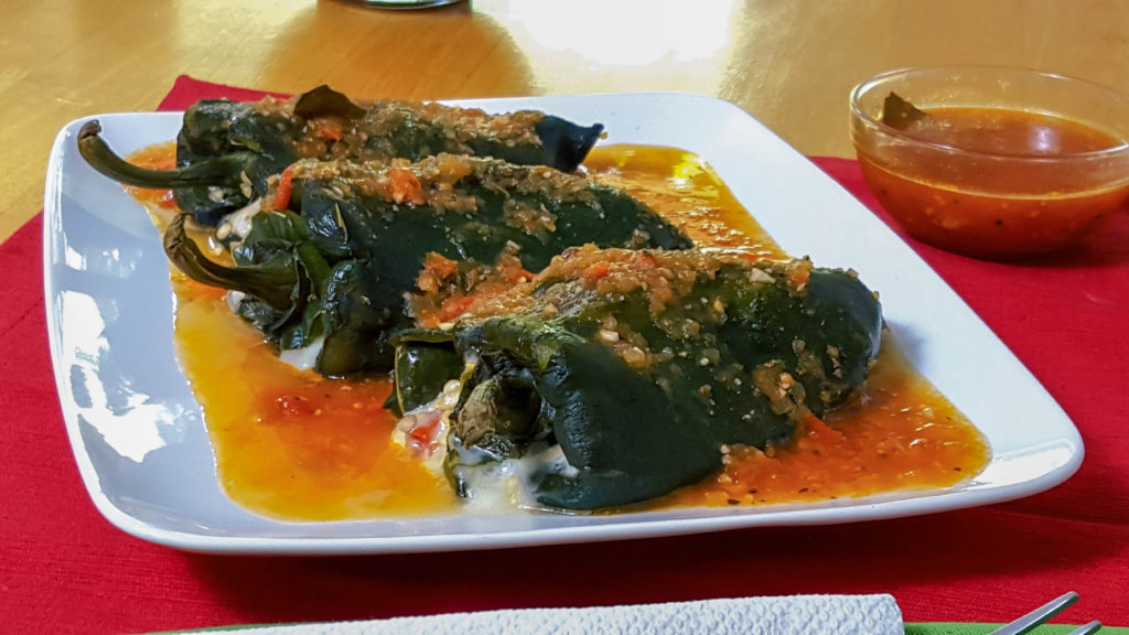 Stuffed Poblano peppers served in a white platter.